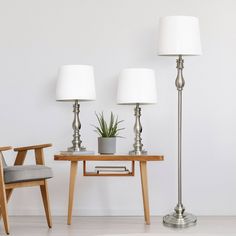 two lamps are next to a table with a potted plant on it