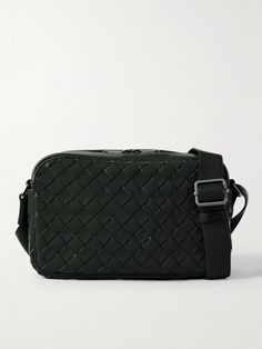 Bottega Veneta's slogan in the '70s was "When Your Initials Are Enough"; referring to its logo-less approach. Just as timeless, this camera bag is woven using the house's signature intrecciato technique from dark-green leather. Carry it over the shoulder with the adjustable shoulder strap. Square Shoulder Bag With Intrecciato Weave For Travel, Designer Woven Leather Travel Bag, Designer Travel Bag With Woven Leather, Luxury Woven Leather Shoulder Bag For Travel, Luxury Woven Leather Travel Shoulder Bag, Luxury Rectangular Camera Bag With Removable Pouch, Classic Woven Leather Shoulder Bag For Travel, Rectangular Intrecciato Travel Bag, Luxury Intrecciato Weave Shoulder Bag For Travel