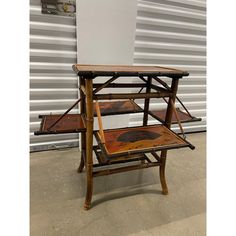 an old wooden table with three trays on it's sides and one sitting on the floor