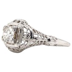 an antique style diamond ring with filigrees