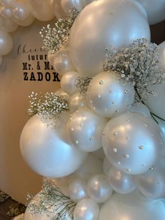 white balloons and baby's breath flowers on display