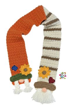 a knitted scarf with flowers and gnomes attached to it, on a white background