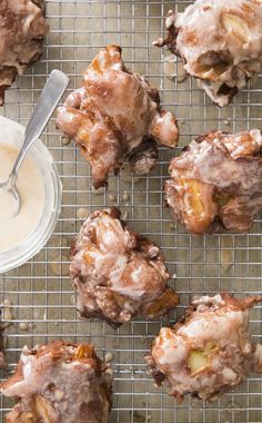 some food is on a cooling rack with a bowl of sauce and spoons next to it