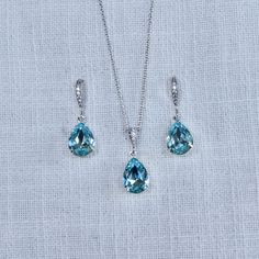 This beautiful handmade small and delicate teardrop crystal dangle bridal earrings, necklace and bracelet feature aquamarine (or aqua) European crystal pear shaped fancy stones. The small pear crystals measure 10x14mm and are hand set in your choice of settings (rhodium (silvertone), yellow or rose gold). The earrings feature cz set french hooks, the necklace features a cz set bail and 18" 925 sterling silver chain and the bracelet features a lobster claw clasp with an extension chain. Really beautiful quality and amazing sparkle perfect for your wedding or special occasion! For pierced ears. Measurements: Earrings: 1-1/4" L x 3/8" W Necklace: 18" L Drop: 1" Bracelet: Adjustable bolo bracelet--will fit any size wrist Available with rhodium plate (silvertone), yellow or rose gold plated fin Teardrop Aquamarine Jewelry For Formal Occasions, Aquamarine Teardrop Jewelry For Formal Occasions, Formal Teardrop Aquamarine Jewelry, Blue Briolette Necklace For Wedding, Teardrop Aquamarine Jewelry For Anniversary, Anniversary Jewelry Sets With Sparkling Teardrop Stones, Anniversary Teardrop Jewelry Sets With Sparkling Stones, Turquoise Teardrop Wedding Jewelry, Elegant Turquoise Jewelry Sets For Wedding