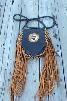 This beaded bear paw handbag is made in black leather with saddle tan lace. The measurements are 7.5 inches x 6 inches x 1.5 inches. This beaded bear paw bag has fringe down the sides , front and back. The 4 point braided shoulder strap measures 48 inches. This leather handbag has a beaded bear paw on the front flap and an extra pocket inside. Ready to ship Leather Mobile Phone Bag For Festivals, Black Shoulder Bag With Cell Phone Pocket For Festivals, Small Leather Phone Bag, Brown Bags With Bear Design For Everyday Use, Brown Bear Design Bags For Everyday Use, Beaded Bear Paw, Beaded Bear, Leather Top Hat, Leather Medicine Bag