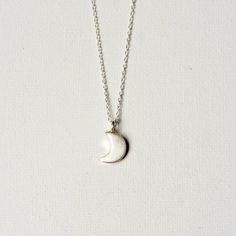 This necklace features the sweetest little crescent moon charm on dainty but sturdy sterling silver cable chain. The charm is about 13mm long (including the loop) and about 7mm wide. A perfect everyday necklace! It is fastened with a sterling spring ring clasp and you can choose your desired length from the drop-down menu above. You can find more celestial jewelry here: www.etsy.com/ca/shop/juliegarland/search?search_query=celestial+jewelry Dainty Moon-shaped Jewelry For Everyday, Everyday Half Moon Phase Necklace, Celestial Half Moon Necklace For Everyday, Everyday Half Moon Charm Necklace, Everyday Celestial Half Moon Necklace, Minimalist Jewelry With Moon Charm, Minimalist Everyday Necklaces With Moon Phase, Elegant Sterling Silver Crescent Charm Necklace, Minimalist Half Moon Phase Necklace