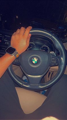 a person driving a car with their hand on the steering wheel and holding onto his wrist