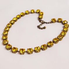 A classic collet necklace will make a great addition to your jewelry collection! These necklaces are so versatile for everyday or formal wear, and are beautiful alone or layered with other necklace. This listing is for a necklace made with vintage Swarovski crystals in a rich, deep yellow.  These stones shine like a warm summer day! Stone Size: 12mm / 1/2 inch long / 1.2 cm long Stone Material: Vintage Swarovski Crystals in Dark Yellow. Settings: Heavy cast Brass with your choice of Gold, Silver, Antique Gold, or Antique Silver plate, connected at the top to prevent the settings from flipping around and showing the back. Gold plate is shown. Length: 16" (40.6cm) with a 2" extender chain for flexible sizing I have over a hundred different necklaces available in my shop, so the layering poss Classic Gold Crystal Bridal Necklace, Classic Citrine Necklaces For Formal Occasions, Classic Yellow Necklace For Wedding, Classic Yellow Wedding Necklace, Collet Necklace, Mustard Yellow Wedding, Riviere Necklace, Deep Yellow, Swarovski Crystal Necklace