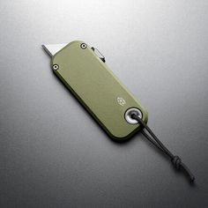 a green pocket knife with a cord attached to it