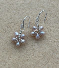 Beautiful mini freshwater pearls in a pale, champagne pink are sterling wire wrapped as petals into flowers in these cute, petit flower dangle earrings on sterling French wires. All sterling silver wire and findings. Dangle length below the ear lobe is a bit more than 1/2 inch or approximately 15mm. Earrings come with rubber back ear clutches so they won't back out of your pierces, and you won't loose them! Earrings in this shop are non returnable due to hygienic reasons. Thanks for checking out my listings! Pearl Wire Earrings, Pink Pearl Drop Earrings In Sterling Silver, Sterling Silver Flower Earrings With Pearl Drop, Delicate Flower-shaped Pearl Earrings With Ear Wire, Delicate Flower Shaped Pearl Earrings With Ear Wire, Dainty Silver Flower Earrings With Pearl Drop, Delicate Pink Pearl Earrings, Pearl Flower Earrings, Champagne Pink