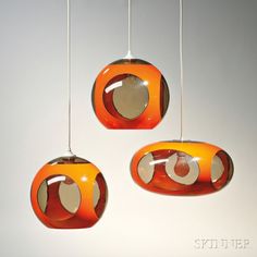 three orange and white hanging lights with circles on them