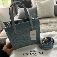 Coach Field Tote 22in Denim Collection. New With Tags. Has Dustbag. Has Strap. Signature Denim And Refined Calf Leather Inside Zip Pocket Snap Closure, Fabric Lining Handles With 4" Drop Detachable Strap With 24 1/2" Drop For Shoulder Or Crossbody Wear Four Protective Feet At Base 8 3/4" (L) X 8 1/4" (H) X 4 3/4" (W) Style No. Cj853 Luxury Denim Blue Bag For Daily Use, Designer Denim Travel Bag, Designer Denim Bags For Everyday Use, Luxury Denim Blue Shoulder Bag For Daily Use, Trendy Denim Bags With Dust Bag Included, Luxury Blue Denim Bag, Luxury Denim Shoulder Bag For Daily Use, Luxury Denim Bag For Daily Use, Casual Denim Shoulder Bag With Dust Bag