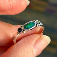 I am selling an Australian Black opal and sapphire sterling silver ring from my collection. It is stamped 925 inside. The ring is in good condition and shows just typical scuffing of the sterling from being worn. There are no scratches to the stones. Light cornflower blue sapphires are 0.27ct total. Ring is a size 10. The opal is solid opal. Sterling Silver Multi-stone Opal Promise Ring, Silver Three Stone Opal Ring For Anniversary, Multi-stone Sterling Silver Opal Ring, Sterling Silver Opal Anniversary Ring, Silver Three Stone Opal Ring, Sterling Silver Multi-stone Opal Ring, Sterling Silver Opal Ring With Multi-stone Design, Oval Multi-stone Opal Ring In Sterling Silver, Oval Opal Ring Stamped 925