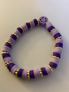 a purple beaded bracelet with a smiley face on it