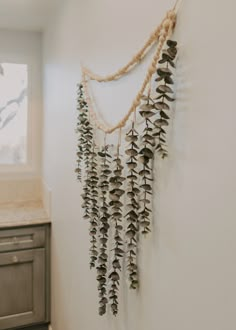 there is a wall hanging made out of shells and plants on the side of the wall