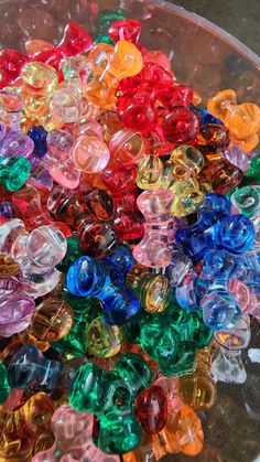 there are many different colored beads in the bowl