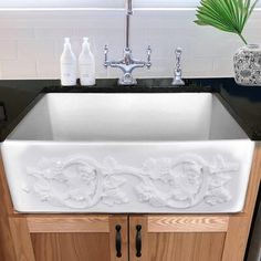 a white kitchen sink sitting under a window