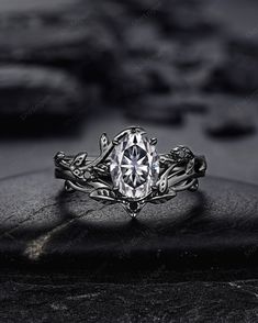 a close up view of a ring with an intricate design on the band and center stone