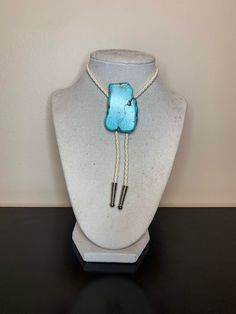 Turquoise faux stone, white braided leather adjustable bolo tie. Stone sizes and shapes vary, they will not be shaped exactly like the one pictured. Western Lariat Bolo Tie With Adjustable Length, Western Style Lariat Bolo Tie With Adjustable Length, Adjustable Southwestern Lariat Jewelry, Western Style Necklace With Adjustable Cord, Southwestern Adjustable Bolo Tie With Sliding Knot, Western Style Lariat Jewelry With Adjustable Length, Handmade Adjustable Western Bolo Ties, Bohemian Adjustable Lariat Bolo Tie, Bohemian Lariat Bolo Tie Adjustable