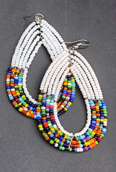 Stand out and make a statement with these stunning colorful tribal style earrings. Traditional Kenya style earrings crafted from seed beads. Pierced. Multi color tribal style beaded earrings. Your purchase empowers women in Kenya to build a sustainable business, alleviate extreme poverty and to support their families with dignity. ******SHIPMENT DE;LAY OF NEW STOCK - AWAITING ARRIVAL OF SEVERAL COLORS - EXPECTED ANYDAY******* Multicolor Beaded Teardrop Earrings, Multicolor Beaded Teardrop Dangle Earrings, Multicolor Teardrop Beaded Earrings With Tiny Beads, Multicolor Teardrop Beaded Earrings, Bohemian Multicolor Teardrop Earrings With Dangling Beads, Bohemian Multicolor Teardrop Earrings With Colorful Beads, Multicolor Teardrop Jewelry With Colorful Beads, White Beaded Teardrop Earrings, White Teardrop Earrings With Colorful Beads