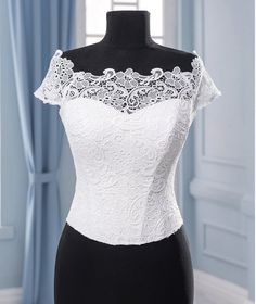 a mannequin wearing a white top with lace on the neck and shoulderline