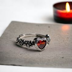 Our adjustable garnet heart rose ring is a intricate statement piece that combines the charm of the Victorian era with a macabre gothic twist. 🖤 🦇  The centerpiece of this romantic Victorian ring is a stunning red garnet heart, symbolizing deep love, passion, and devotion. ♥️ 🥀  This stunning ring is the perfect accessory for anyone who loves gothic, boho, or witchy jewelry. The vintage Victorian vampire design is both elegant and eerie, making this ring a truly unique statement piece. ️ 💍 T Gothic Rings For Valentine's Day Gift, Valentine's Day Gothic Rings As Gift, Vintage Halloween Rings As Gifts, Vampire Design, Vampire Jewelry, Gothic Boho, Victorian Vampire, Garnet Heart, Victorian Ring