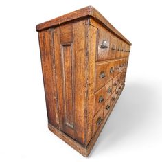 an old wooden chest with many drawers and knobs on the front, against a white background