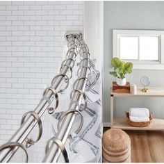 a bathroom with white tile walls and wooden flooring, along with a shower curtain