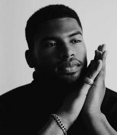 a black and white photo of a man holding his hands together