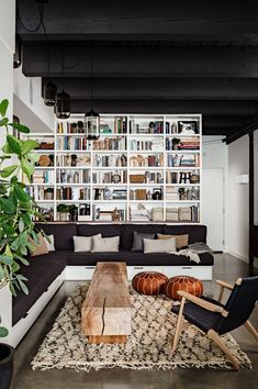 a living room filled with furniture and bookshelves next to a large book shelf