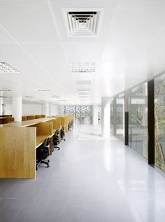 an empty office with wooden desks and glass walls