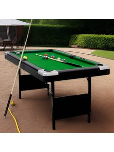 a pool table with two cues and one ball on it in the middle of a yard