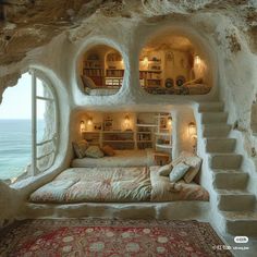 a bed in a cave like room next to the ocean