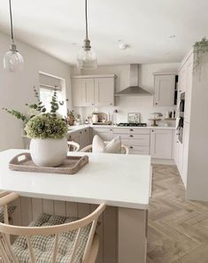 a kitchen with white cabinets and wooden chairs