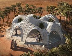 two people are standing in front of a building made out of white wire and palm trees