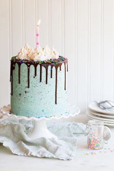 a birthday cake with frosting and sprinkles on it, sitting on a table