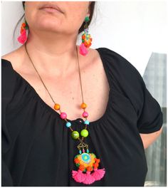 a woman wearing a necklace with colorful beads and tassels