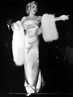 a woman in a white dress and fur stole