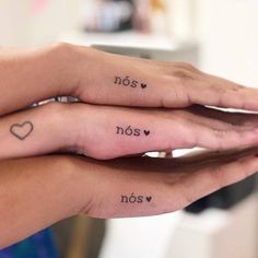 two people with tattoos on their fingers and the words nos noss noss written in small letters