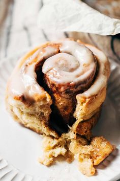 a cinnamon roll on a plate with a bite taken out