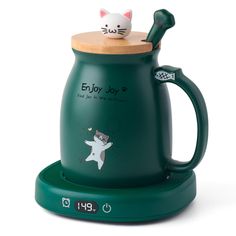 a green coffee mug with a cat on top