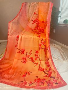 Vibrant and pretty blended satin silk saree in shades of orange. Floral vines is printed on the top portion of the pallu with pebble like prints on the lower part.Pleats will be a bright orange with floral sequins in the bottom part and continues as bright orange towards the end of the saree. Sequin lace borders runs along the saree. Comes with fall, pico and completely stitched blouse. Saree width: 43 inch Blouse details: Back hook with mild puff along the sleeves. chest size: 36 with 3 inch ma Orange Bollywood Saree With Cutdana, Orange Cutdana Saree, Semi-stitched Orange Saree, Saree Orange, Bohemian Orange Semi-stitched Saree, Satin Silk Saree, Blouse Details, Sequin Saree, Orange Saree