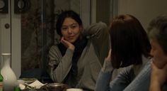 two women sitting at a table with food in front of them and one woman leaning on her head