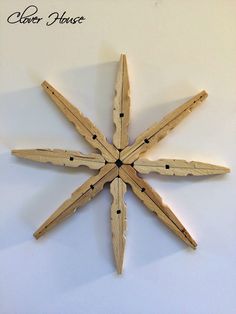 a snowflake made out of wooden sticks on a white wall