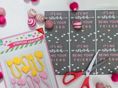 some crafting supplies are laying out on a table with pink and yellow decorations around them