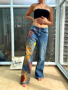 Hand painted Sun Worship jeans. Super cute and colourful piece, ideal for fall and festivals. A unique and happy piece! Baggy, wide leg fit, can fit up to a UK 12, depending on desired fit- modelled on a UK 8. The piece is created with acrylic paint and acrylic fabric medium, then heat sealed for durability. Handwash is still advised as it is paint, although they can survive the wash on a cold settinf if they really need! Sourced second hand, originally H&M. Painted Trousers Jeans, Multicolor Wide Leg Denim Jeans, Bohemian Wide Leg Summer Jeans, Spring Graphic Print Denim Pants, Summer Straight Leg Jeans With Graphic Print, Summer Festival Wide Leg Jeans, Wide Leg Summer Festival Jeans, Blue Bohemian Wide Leg Flare Jeans, Wide Leg Jeans For Summer Festivals