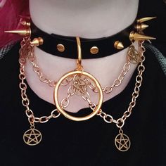 "\"Risen\" is the brass twin to \"Fallen\". \"Risen\" is a stunning statement piece, featuring a hanging 1.5 inch O-ring, 5 small pentacle charms, and 4 brass chains. It's the perfect addition to any punk, goth or grunge outfit, sure to help make you the life of the party (or make it rain compliments at the mall ;] ). The choker in the photos is 16 inches long, with 4 buckle settings at .75 inch spacing. You are welcome (and encouraged!) to request custom measurements, as these are entirely handmade and can be made to order. Sizing note: The preset options listed are for the MAX size setting. For example, if you order a 20 inch choker, the largest setting will be 20 inches, and the smallest will be 17. Please be sure to measure your neck to ensure a proper fit! If you're unsure how to meas Gold Punk Style Choker Jewelry, Punk Gold Choker Jewelry, Gold Punk Necklace For Halloween, Alternative Metal Jewelry For Cosplay, Punk Gold Jewelry For Halloween, Punk Style Gold Jewelry For Halloween, Gold Punk Jewelry For Halloween, Steampunk Jewelry For Halloween Festival, Punk Style Gold Jewelry With Adjustable Chain