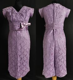 A smart vintage fashion cocktail dress dating to the 1950s. One piece, an under dress in a very silk like synthetic, over layed with purple floral machine lace. Fitted, with a long centre back dyed to match ' Opti ' zip, the bodice with cross over pleats, v neck and short, part grown on sleeves. Below the knee straight skirt with layered vent in the back. Wide waistband in the silk like fabric, with large bow and hook fastening. CONDITION Very good. Some slight fading which hasn't really shown i Purple Lace Dress With Fitted Bodice, Fitted Purple Lace Dress, Formal Lavender Dress With Fitted Bodice, Lavender Lace Evening Dress, Vintage Lavender Dress For Evening, Elegant Lavender Lace Dress, Elegant Purple Lace Dress, Lavender Fitted Formal Dress, Formal Fitted Purple Mother Of The Bride Dress