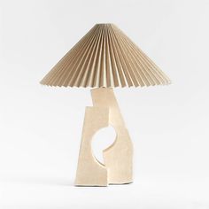 a lamp made out of wood with a paper shade on the base and a circular hole in the middle