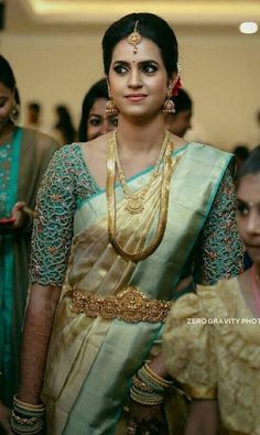 a woman in a sari is walking down the aisle with other people behind her